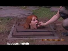 A cute redhead slave gets covered with mud and piss outdoor