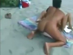 Two lesbians finger and lick each other on the beach