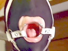 Putting hand made ring gag harness in slave slut mouth