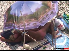 Handjob on candid beach with old nudist couple